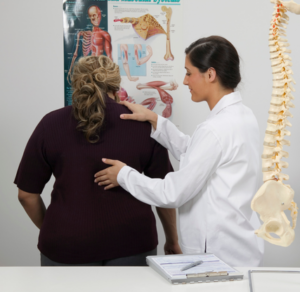 woman who hurt her back after falling is getting a consultation at the chiropractor